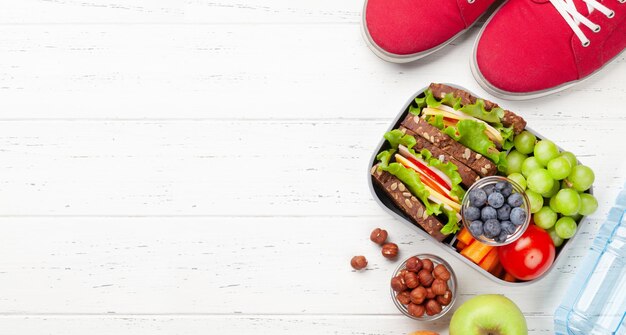 Foto lancheira escolar saudável com sanduíche e vegetais frescos