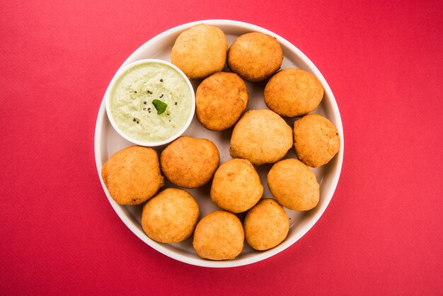 Lanches indianos Aloo Bonda ou batata vada ou urad daal vada ou pakoda ou pakora. Servido com chutney verde. Foco seletivo