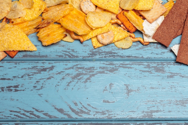 Lanches salgados. Pretzels, batatas fritas, biscoitos. Fundo de produtos não saudáveis