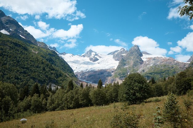 Landschaft, Bergpanorama, Almwiesen und Berggipfel im Eis, ein kleines Haus am Berghang