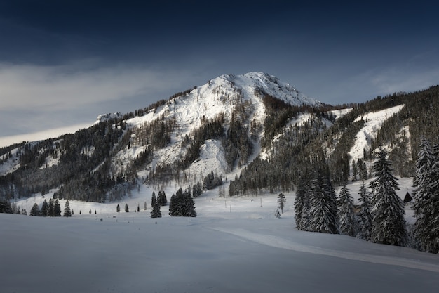 Landschaft der Sonne, die die schneebedeckten Gipfel der hohen Berge beleuchtet