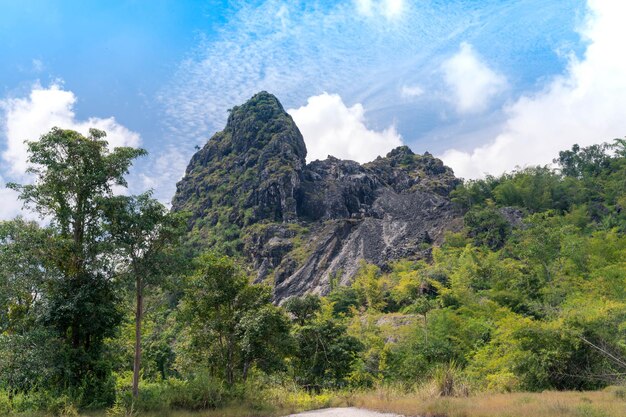 Landschaft des alten Bergbaufelsenberges mit frischem grünem Wald und bewölktem hellblauem Himmel in Thong Pha Phum, Kanchanaburi, Thailand. Kalksteinhügel. Abenteuer Naturreisen.