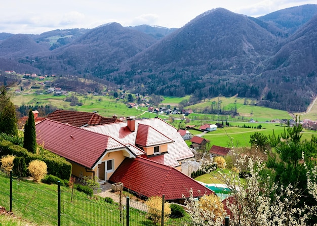 Landschaft des Tals und der Altstadt von Celje in Slowenien. Architektur am grünen Hügel in Slovenija. Alpenberge im Hintergrund.