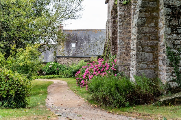 Landschaft des Weges außerhalb eines alten Backsteinmauergebäudes in der Bretagne, Frankreich