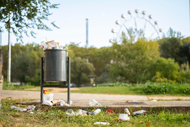 Landschaft eines Parks mit einem Mülleimer voller Müll