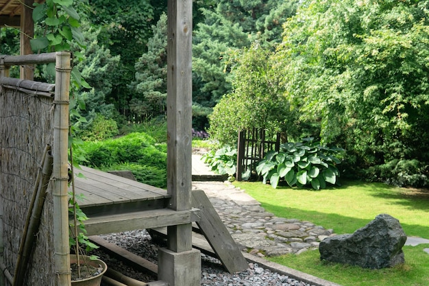 Landschaft eines traditionellen japanischen Gartens mit Pflanzenpfaden und einem Fragment eines Pavillons