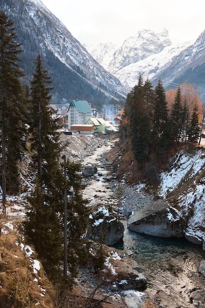 Landschaft in den Bergen, Fluss und Nadelwald, Herbst, der erste Schnee auf den Pisten, umgestürzte Bäume und Sträucher