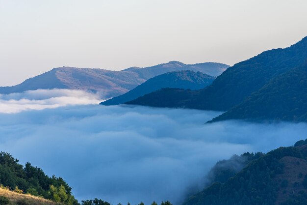 Landschaft mit Bergen und Wolken, die das Tal bedecken, malerische Aussicht in die Natur.