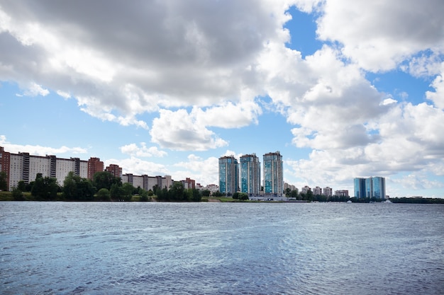 Landschaft mit Bucht, Gebäuden und Himmel mit weißen Wolken