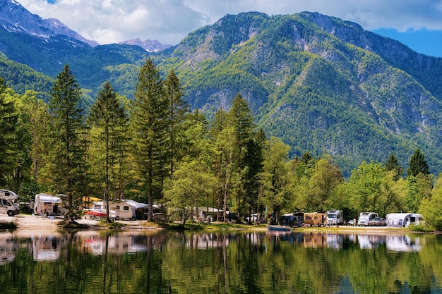 Landschaft mit Camping von Wohnmobilanhängern in der Nähe des Bohinj-Sees, Slowenien. Natur- und Wohnmobile in Slowenien. Blick auf Wohnmobil und grünen Wald. Landschaft im Sommer. Alpine Alpenberge