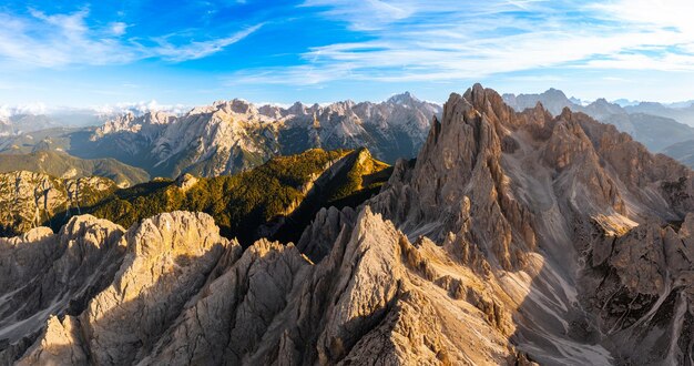 Landschaft mit drei Lavaredo-Gipfeln, sonnigen felsigen Bergketten und hügeligen Schluchten unter blauem Himmel