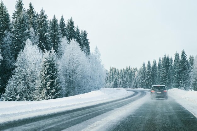 Landschaft mit einem Auto auf der Straße im verschneiten Winter Lappland, Rovaniemi, Finnland