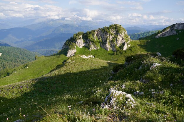 Landschaft mit einem malerischen Felsen in einem grünen Gebirgspass