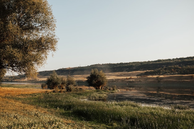 Landschaft mit grünen Bäumen, Hügeln und Fluss in der Landschaft.