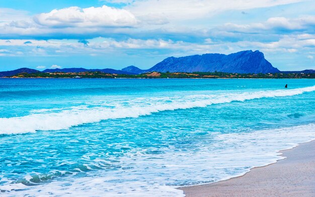 Landschaft mit La Cinta Strand und Mittelmeer und Insel Tavolara in Sardinien auf Italien im Sommer. Landschaftsblick auf den sardischen Strand in Sardinien. Provinz Olbia. Gemischte Medien.