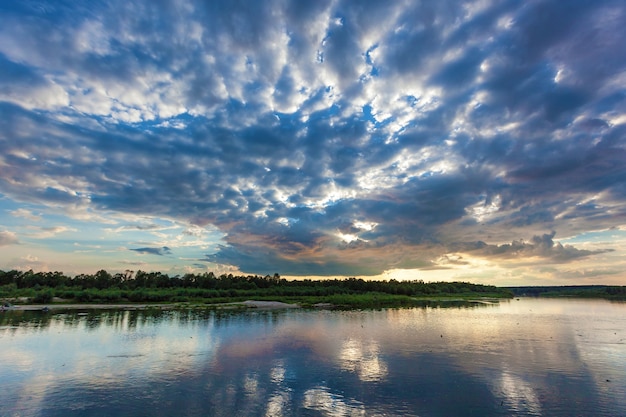 Landschaft mit schönem Sonnenuntergang und Wolken über dem Fluss