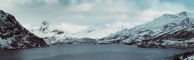 Landschaft mit schönem Wintersee und schneebedeckten Bergen auf den Lofoten-Inseln in Nordnorwegen Panoramablick