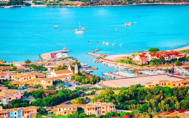 Landschaft und Landschaft von Golfo Aranci an der Costa Smeralda, Insel Sardinien in Italien im Sommer. Provinz Sassari in der Nähe von Olbia und Cagliari. Im Mittelmeer. Yachten, Boote und Schiffe. Gemischte Medien.