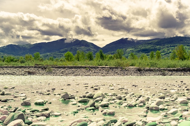 Foto landschaft vom ufer des piave-flusses, grüne wälder, berge und wolken