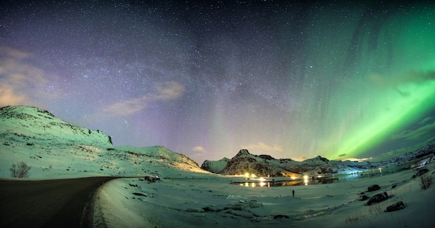 Landschaft von Aurora borealis mit Sternenhimmel über Bergkette an der arktischen Küste