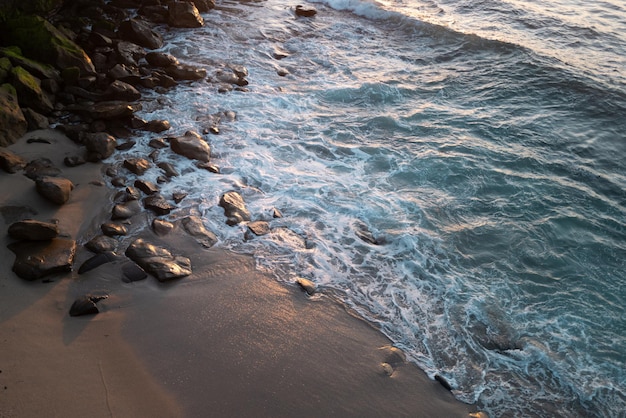 Landschaft von Meer und tropischen Strand Meereswellen und Steinen am Strand Schöne Meereslandschaft Natur Reisen und Urlaub kopieren Platz