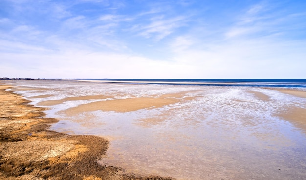 Landschaft von Strand Sand mit Meer und blau bewölktem Himmel Hintergrund an der Ostküste Küstenlinie Kattegat Jütland in der Nähe von Mariager Fjord Dänemark Malerischer Blick auf Meerwasser auf Sand während der Flut