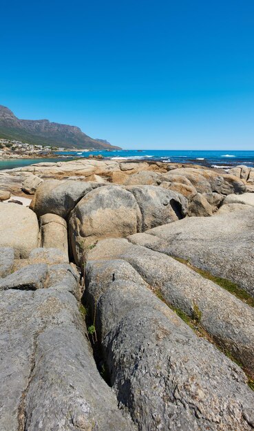 Landschaftlich reizvoller und copyspace Blick auf Felsen und Felsbrocken am Meer oder an der Küste vor einem klaren blauen Himmel im Sommer Schöne friedliche und ruhige natürliche Umgebung am Strand mit Copyspace