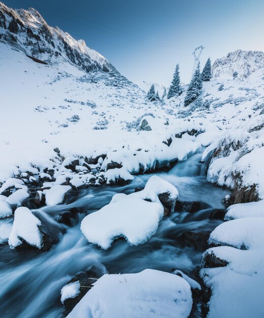 Foto landschaftliche aussicht auf den fluss, der inmitten schneebedeckter berge gegen einen klaren himmel fließt