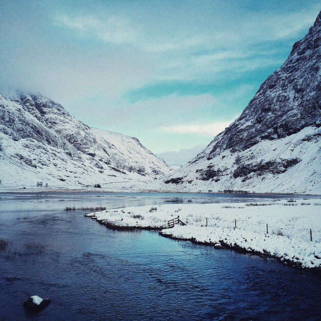 Landschaftliche Aussicht auf den Fluss durch schneebedeckte Berge gegen den Himmel