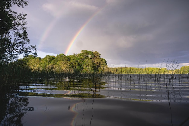 Foto landschaftliche aussicht auf den regenbogen über dem see gegen den himmel