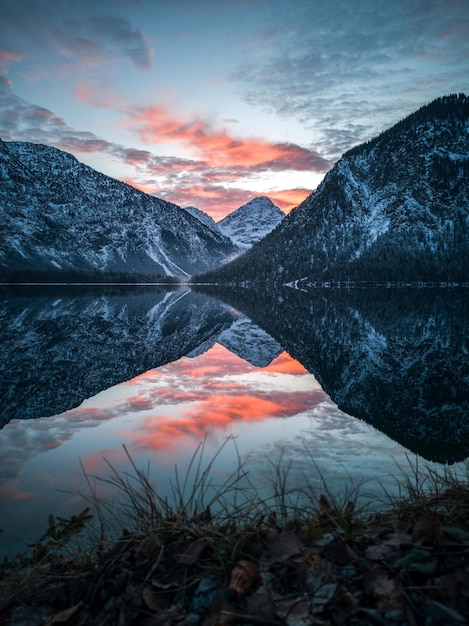 Landschaftliche Aussicht auf den See durch die Berge gegen den Himmel bei Sonnenuntergang