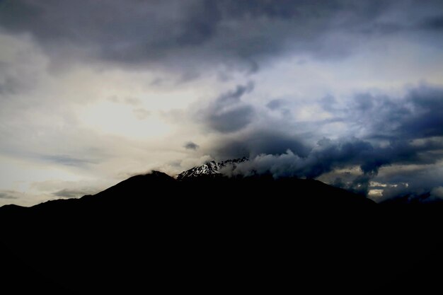 Foto landschaftliche aussicht auf den silhouette-berg gegen den bewölkten himmel in der dämmerung