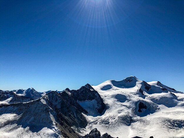 Foto landschaftliche aussicht auf schneebedeckte berge vor einem klaren blauen himmel