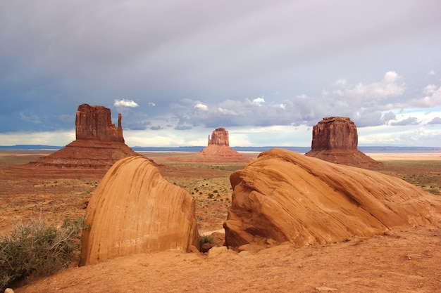 Landschaftliche Aussicht auf Steinstapel im Monument Valley vor bewölktem Himmel