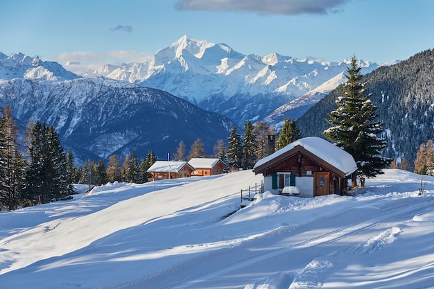 Landschaftsansicht der kleinen Hütten zwischen den verschneiten Bergen