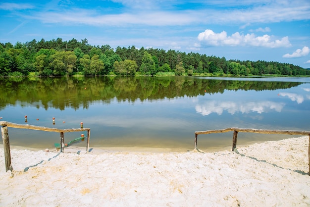 Landschaftsansicht des Sees an einem sonnigen Sommertag, Himmelsreflexion im Wasser, Sandstrand