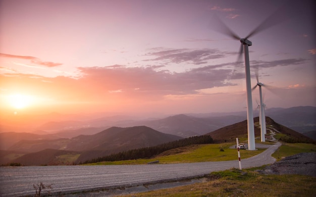 Landschaftsansicht von äolischen Generatoren auf einem Hügel bei Sonnenuntergang