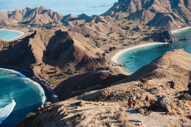 Landschaftsansicht von der Spitze der Insel Padar bei Labuan Bajo mit Touristen, die den Hügel hinuntergehen?