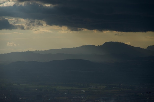 Landschaftsansicht vor einem bewölkten Himmel beim Sonnenuntergang