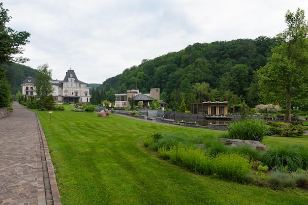 Foto landschaftsdesign. bäume, büsche, grüne wiesen. schöner park in der nähe des grünen waldes.