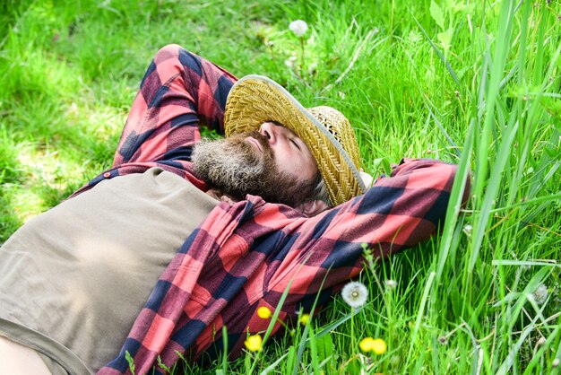 Landsmann auf grüner Wiese. grüne Umwelt schützen. Landwirtschaftsbauer ruhen sich nach der Tagesarbeit aus. Arbeiter im ländlichen Bauernhof. Bauer entspannen sich auf grünem Gras. Ökologie-Konzept. Grünes Feld im Sommer.