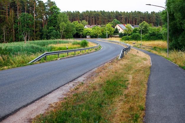 Landstraße durch das Feldhaus oder den Bauernhof in der Nähe des Waldes Idyllische ländliche Szene Natur Dorf Landwirtschaft Ernte Ökotourismus Themen