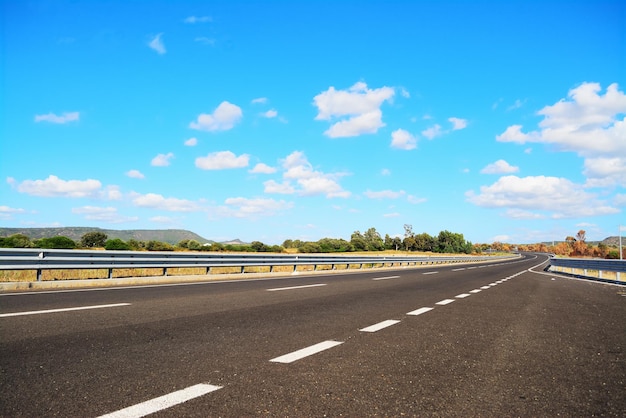 Landstraße unter blauem Himmel mit weichen Wolken