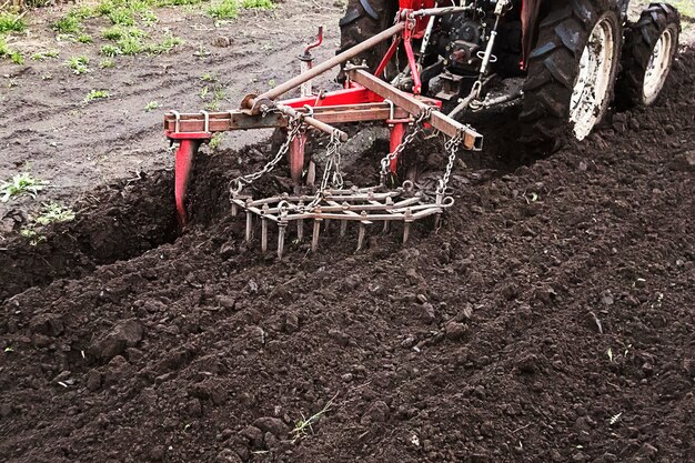 Landwirt bereitet Land für die Aussaat vor. Traktor, der auf dem Bauernhof arbeitet, ein moderner landwirtschaftlicher Transport, der auf dem Feld arbeitet, fruchtbares Land, Landbewirtschaftung, landwirtschaftliche Maschine, Kopienraum, Kopienraum.