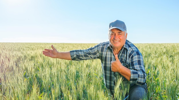 Landwirt, der auf dem landwirtschaftlichen Gebiet eine Geste mit dem Daumen nach oben macht