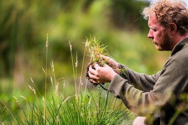 Landwirt, der Bodenproben in einem Reagenzrohr auf einem Feld sammelt Agronom, der Bodenkohlenstoff und Pflanzengesundheit auf einem Bauernhof überprüft