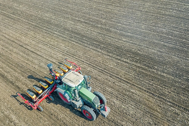 Landwirt, der Getreide auf dem Feld aussät. Seeding-Luftbild.