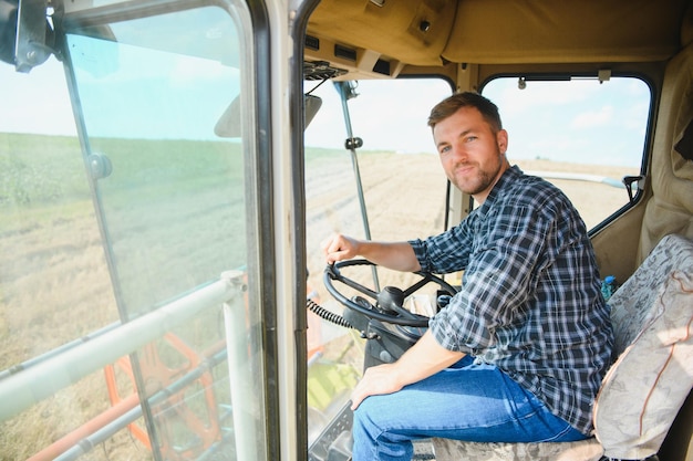 Landwirt, der Mähdrescher fährt und Getreide erntet