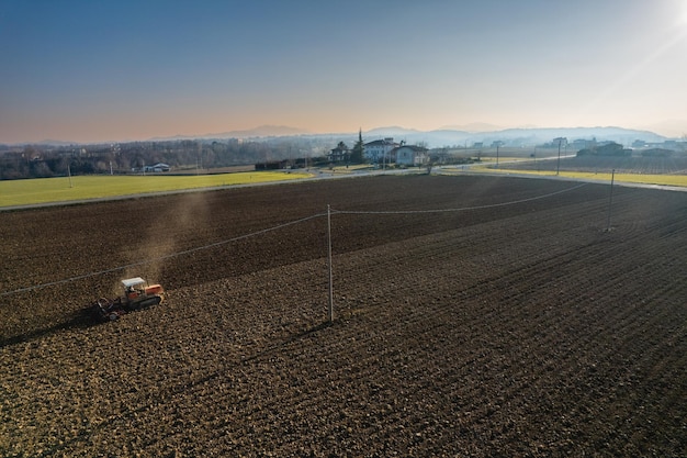 Landwirt fährt mit einem Raupentraktor und pflügt und hackt die Bodenkruste, um die Geburt und Aussaat von Pflanzen auf trockenem Boden zu erleichtern