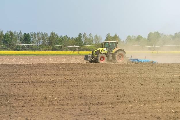 Landwirt im Traktor, der Landsaatbettgrubber vorbereitet. Landwirtschaft Traktorlandschaft.